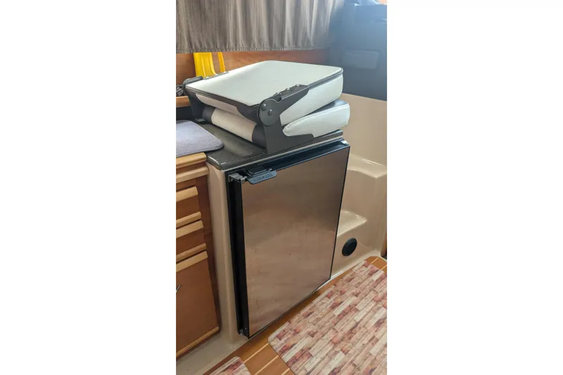 Kameleon Yacht Photos Pics 2017 Cutwater C28 interior with compact fridge and folded seat cushions.