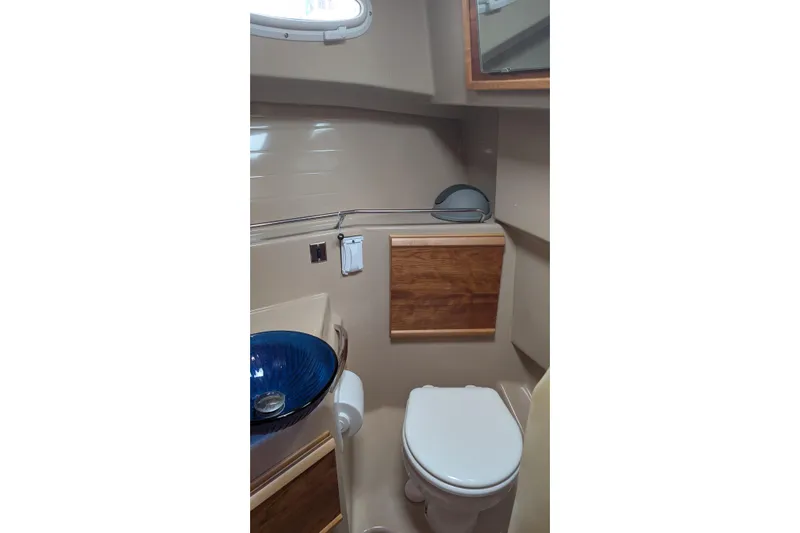Kameleon Yacht Photos Pics 2017 Cutwater C28 boat bathroom with modern sink, toilet, and wooden cabinetry.