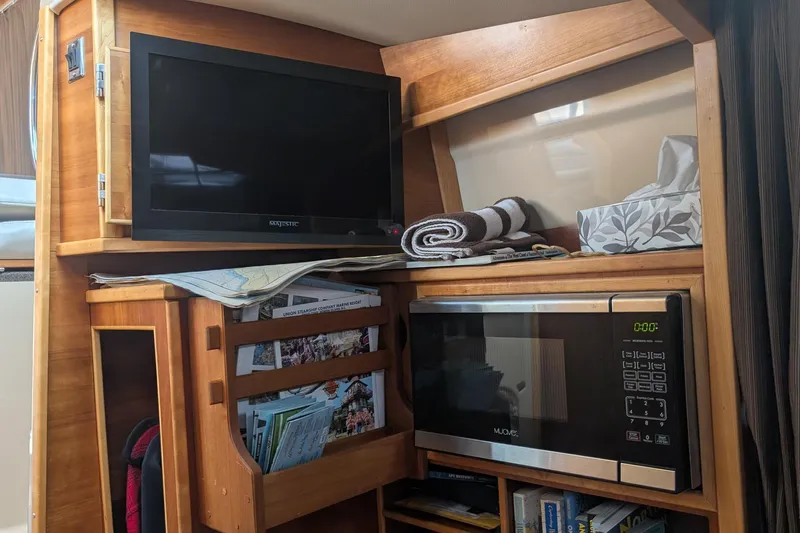 Kameleon Yacht Photos Pics Interior of 2017 Cutwater C28 with TV, microwave, and storage shelves.