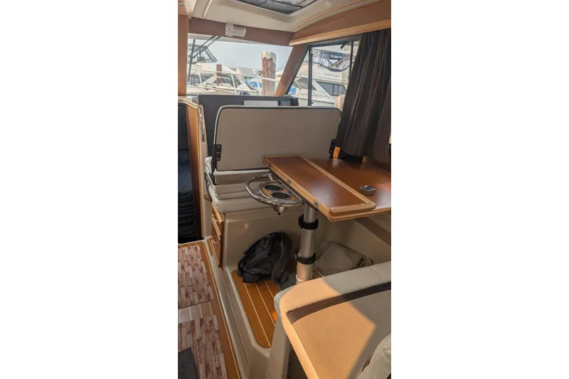 Kameleon Yacht Photos Pics 2017 Cutwater C28 interior with wooden table and seating, docked at marina.