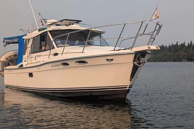 Kameleon Yacht Photos Pics 2017 Cutwater C28 boat on calm water with forested shoreline in background.