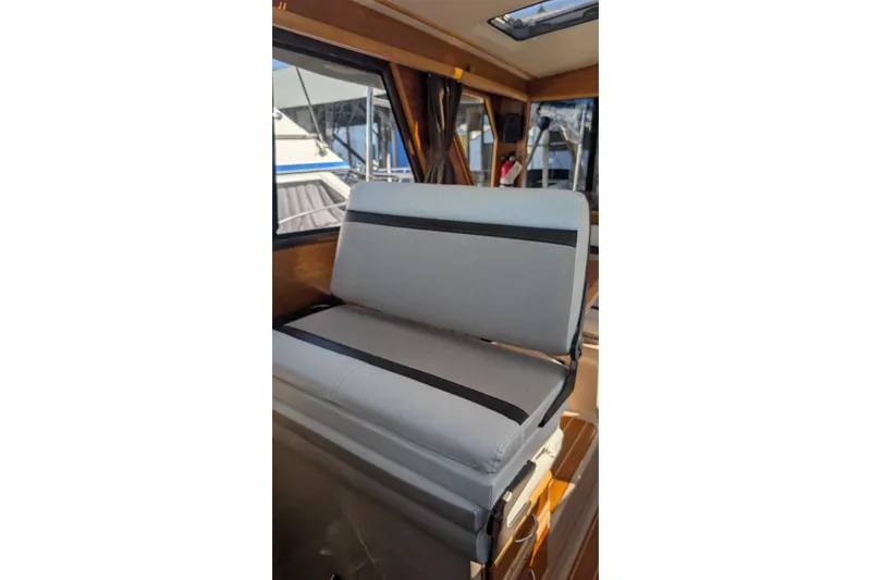 Kameleon Yacht Photos Pics 2017 Cutwater C28 interior with cushioned seating and window view.