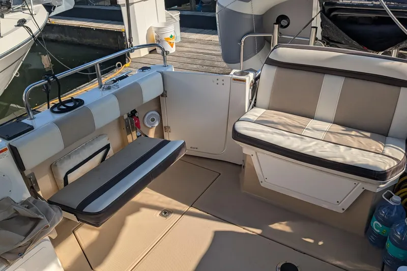 Kameleon Yacht Photos Pics 2017 Cutwater C28 boat interior with cushioned seating and dock view.