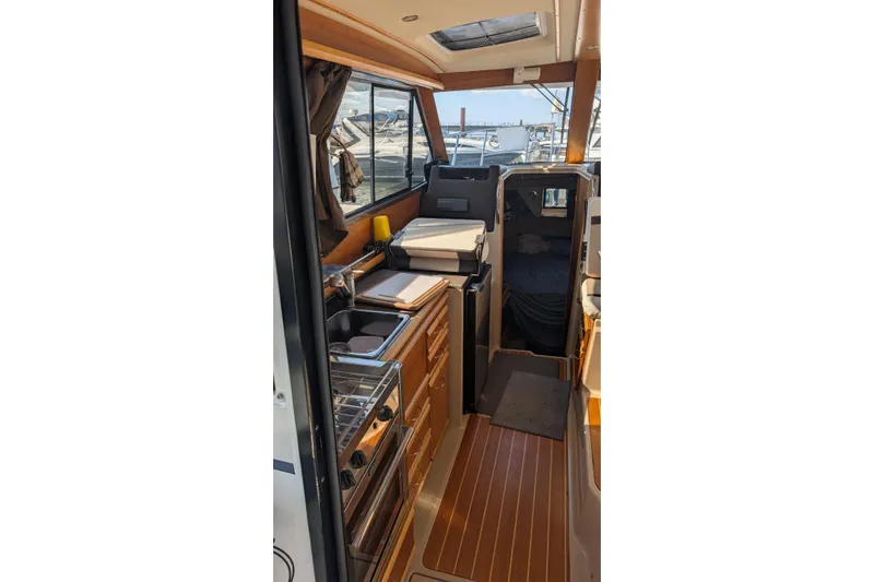 Kameleon Yacht Photos Pics Interior of 2017 Cutwater C28 boat featuring compact kitchen and cozy cabin space.