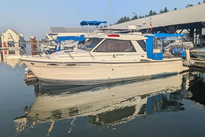 Kameleon Yacht Photos Pics 2017 Cutwater C28 boat docked at a marina, reflecting on calm water.