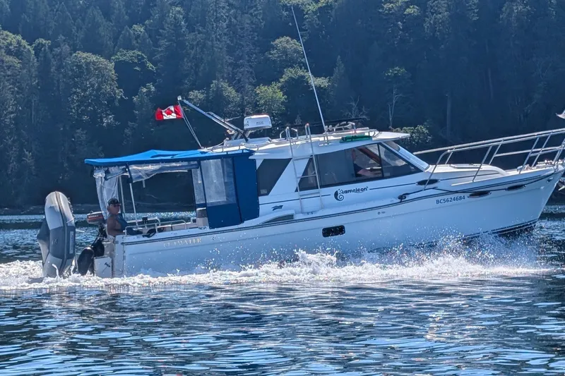 Kameleon Yacht Photos Pics 2017 Cutwater C28 boat cruising on a scenic lake with forested background.