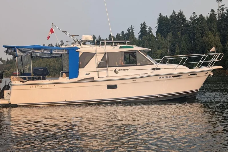 Kameleon Yacht Photos Pics 2017 Cutwater C28 boat on calm water with forested background.