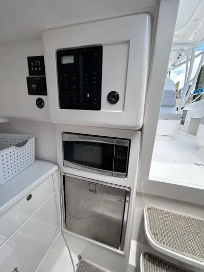 No Name Yacht Photos Pics 2016 Intrepid 375 Walkaround interior with control panel, microwave, and storage.