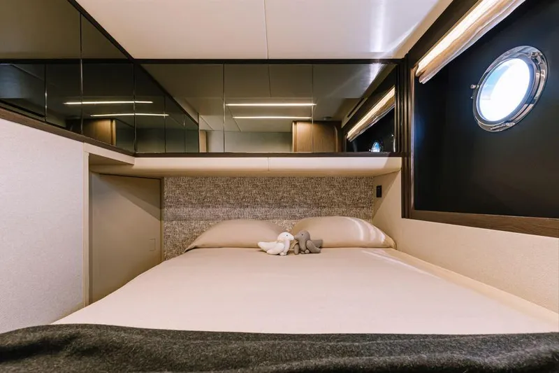 Absolute 52 Fly Yacht Photos Pics Luxurious bedroom interior of 2025 Absolute 52 FLY yacht with modern design and porthole window.