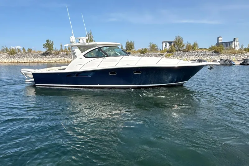 Nomad Yacht Photos Pics 2019 Tiara Yachts 39 Open cruising on a sunny day near a rocky shoreline.