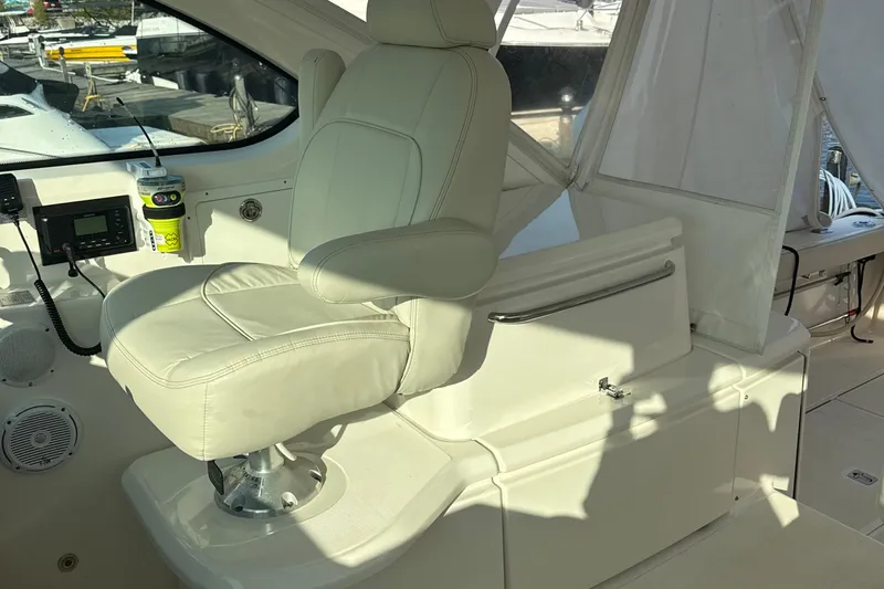 Nomad Yacht Photos Pics Captain's chair on 2019 Tiara Yachts 39 Open, featuring helm controls and cup holder.
