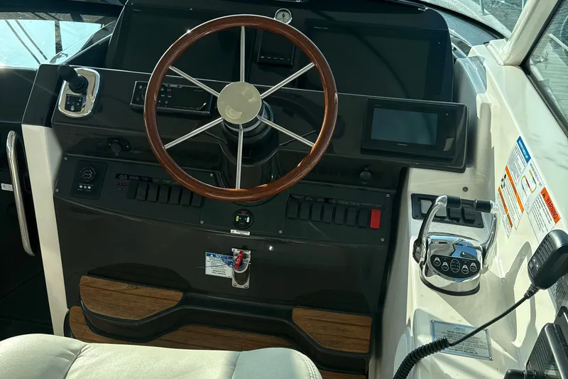 Nomad Yacht Photos Pics Helm of 2019 Tiara Yachts 39 Open with wooden steering wheel and modern controls.