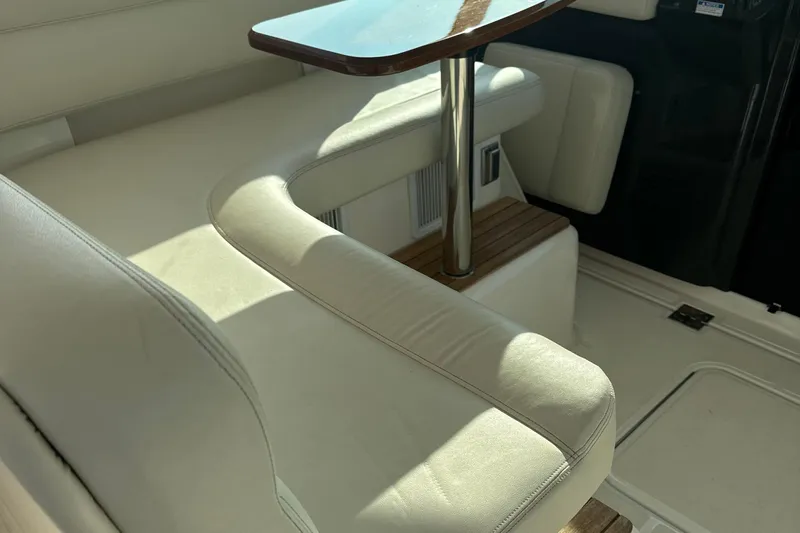 Nomad Yacht Photos Pics Luxurious seating area on 2019 Tiara Yachts 39 Open, featuring elegant upholstery and wooden table.
