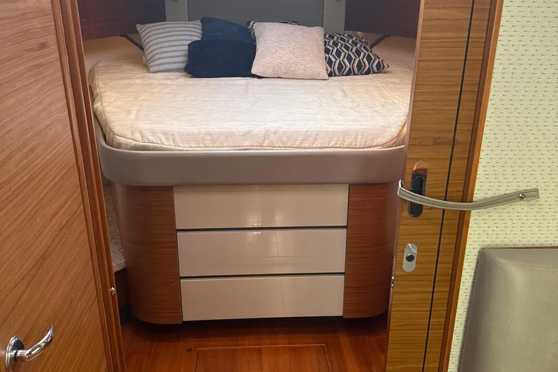 Nomad Yacht Photos Pics Cabin interior of 2019 Tiara Yachts 39 Open with bed and pillows.