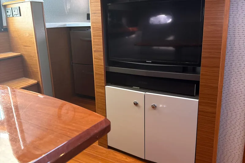 Nomad Yacht Photos Pics Interior of 2019 Tiara Yachts 39 Open with TV and wooden cabinetry.