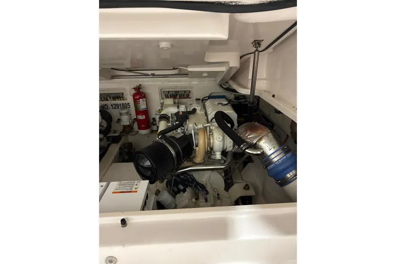 Nomad Yacht Photos Pics Engine compartment of a 2019 Tiara Yachts 39 Open, featuring mechanical components and fire extinguisher.