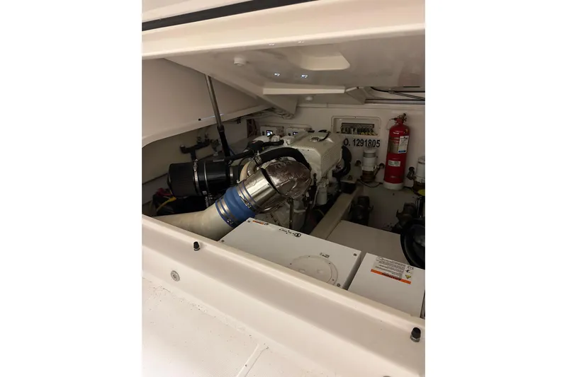 Nomad Yacht Photos Pics Engine compartment of 2019 Tiara Yachts 39 Open, featuring mechanical components and fire extinguisher.