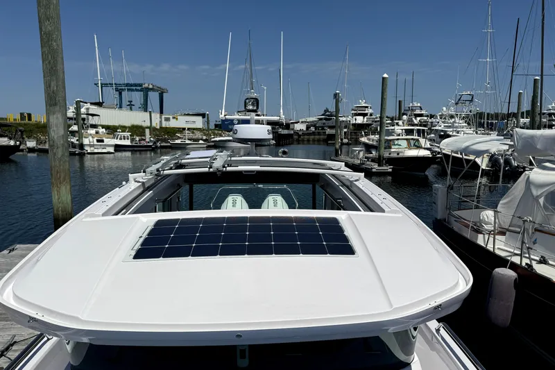  Yacht Photos Pics 2024 Axopar 37 XC CROSS CABIN docked in a marina, featuring a solar panel on the roof.