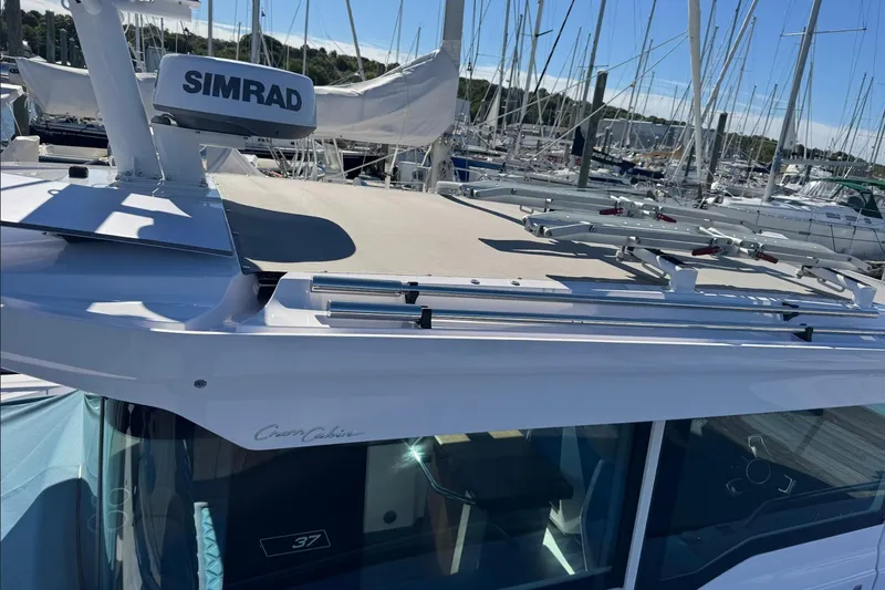  Yacht Photos Pics 2024 Axopar 37 XC CROSS CABIN boat with Simrad equipment in a marina setting.