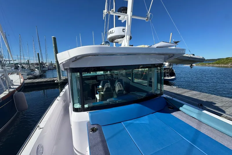  Yacht Photos Pics 2024 Axopar 37 XC CROSS CABIN docked at marina under clear blue sky.