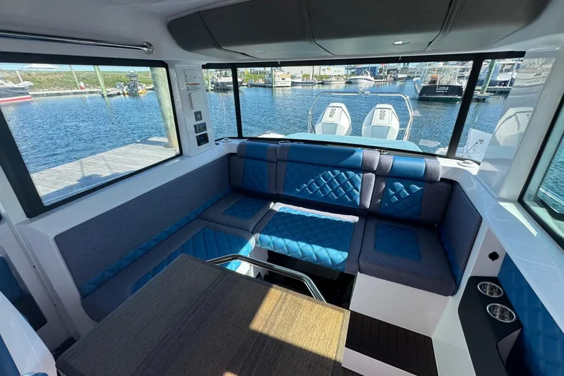  Yacht Photos Pics Interior of 2024 Axopar 37 XC CROSS CABIN with blue seating and waterfront view.