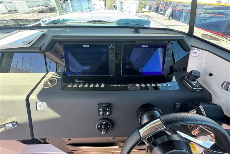  Yacht Photos Pics 2024 Axopar 37 XC CROSS CABIN dashboard with dual Simrad displays and steering wheel.