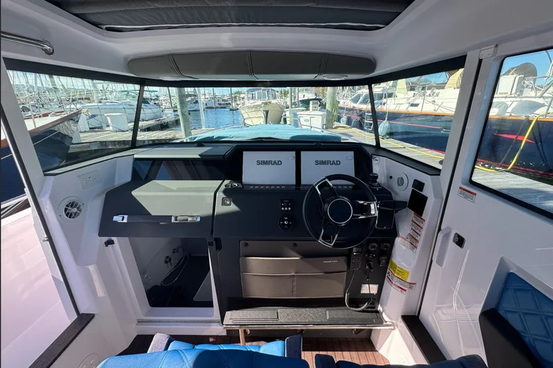  Yacht Photos Pics 2024 Axopar 37 XC CROSS CABIN helm with Simrad displays, docked at marina.