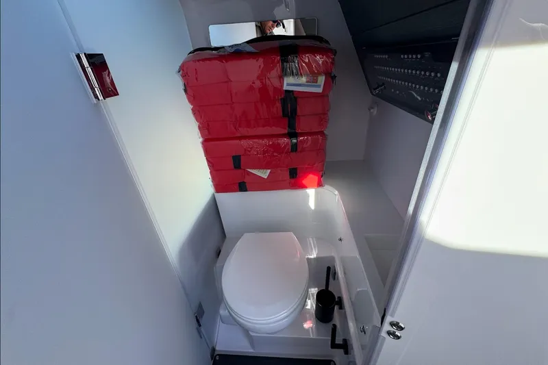  Yacht Photos Pics 2024 Axopar 37 XC CROSS CABIN bathroom with toilet and red life jackets.