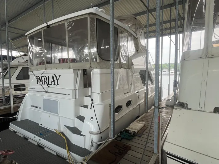  Yacht Photos Pics 1999 Silverton 392 Aft Cabin yacht docked in marina, covered and well-maintained.