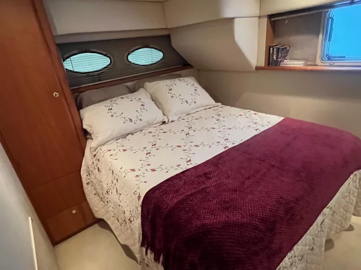  Yacht Photos Pics Cozy bedroom in 1999 Silverton 392 Aft Cabin with floral bedding and porthole windows.