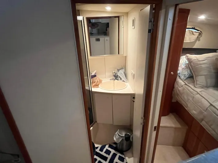  Yacht Photos Pics 1999 Silverton 392 Aft Cabin bathroom with sink, mirror, and adjacent bedroom.