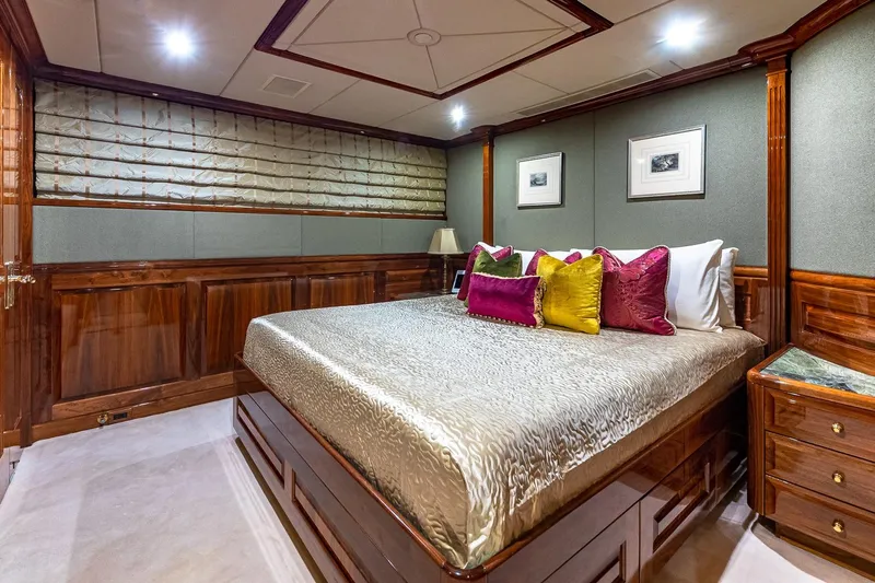 Amore Yacht Photos Pics Luxurious bedroom interior on 2005 Christensen motor yacht with elegant wood paneling and vibrant pillows.