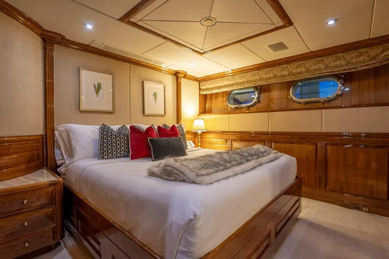 Amore Yacht Photos Pics Luxurious bedroom interior on a 2005 Christensen motor yacht, featuring elegant wood paneling.