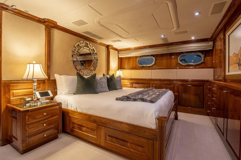 Amore Yacht Photos Pics Luxurious bedroom interior on 2005 Christensen motor yacht, featuring elegant wood paneling and plush bedding.