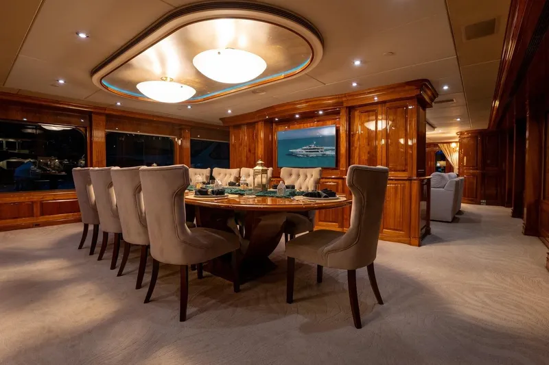 Amore Yacht Photos Pics Luxurious dining area on 2005 Christensen motor yacht with elegant wood paneling and plush seating.