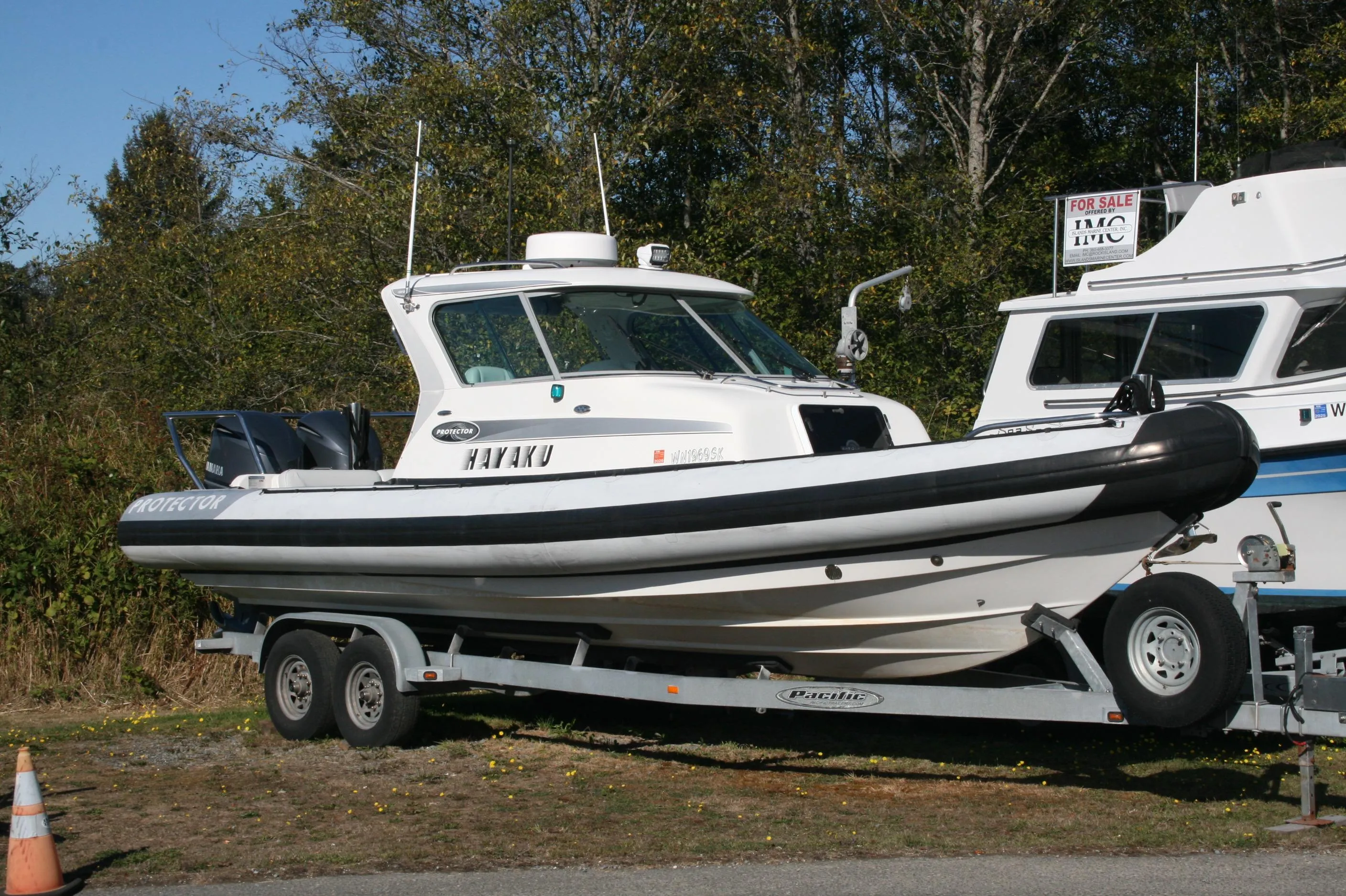 2012 Protector Targa 30 boat on trailer, parked outdoors, with "For Sale" sign.