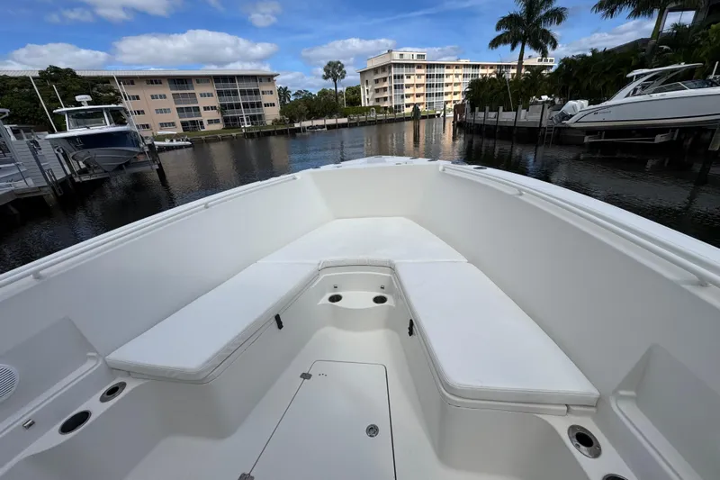  Yacht Photos Pics 2016 Sailfish 320 CC boat interior with white seating, docked near waterfront buildings.