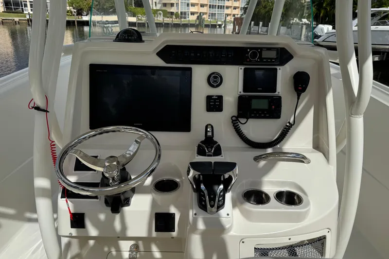  Yacht Photos Pics Control panel of a 2016 Sailfish 320 CC boat with steering wheel and navigation equipment.