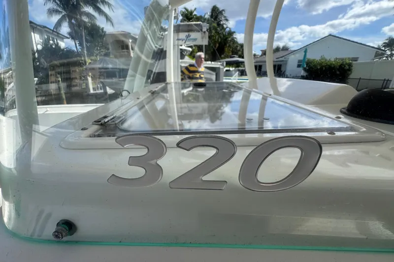  Yacht Photos Pics 2016 Sailfish 320 CC boat with clear windshield and tropical background.