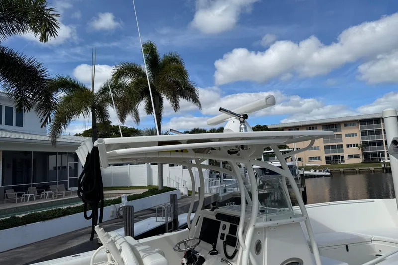  Yacht Photos Pics 2016 Sailfish 320 CC boat docked near palm trees and waterfront buildings.