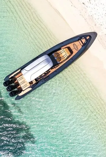  Yacht Photos Pics Aerial view of 2018 Bernico RX10 boat on clear turquoise water near sandy beach.