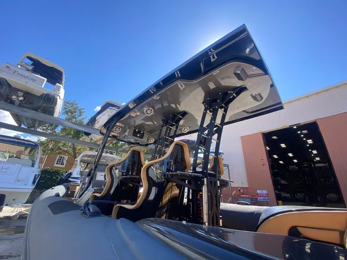  Yacht Photos Pics 2018 Bernico RX10 boat with sleek seating and canopy, parked outdoors under clear blue sky.