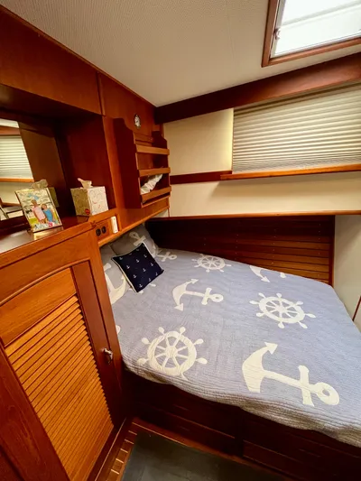  Yacht Photos Pics Cozy cabin interior of 1997 Grand Banks 49 Classic with nautical-themed bedding.