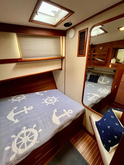  Yacht Photos Pics 1997 Grand Banks 49 Classic cabin with nautical-themed bedding and wooden interior.