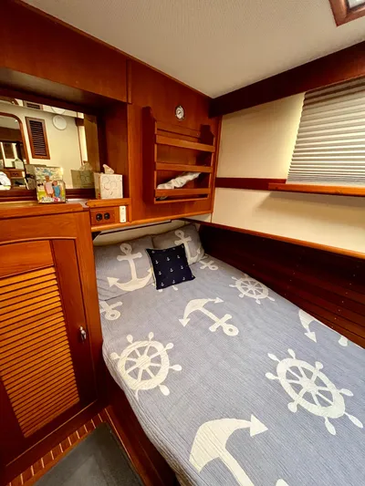  Yacht Photos Pics Cozy cabin interior of 1997 Grand Banks 49 Classic with nautical-themed bedding.