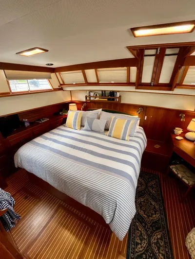  Yacht Photos Pics Luxurious 1997 Grand Banks 49 Classic yacht bedroom with striped bedding and elegant wood finishes.