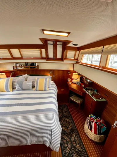  Yacht Photos Pics Interior of 1997 Grand Banks 49 Classic yacht with cozy bedroom and striped bedding.