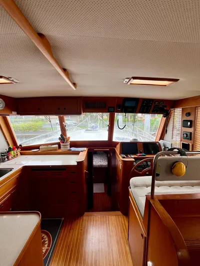  Yacht Photos Pics Interior of a 1997 Grand Banks 49 Classic yacht, featuring a wooden helm and kitchen area.