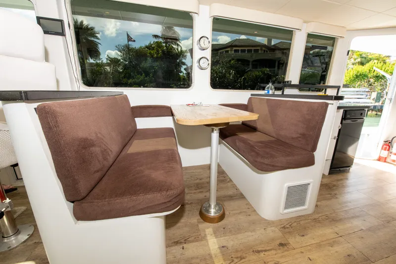 Sarah B Yacht Photos Pics Interior of 2007 Custom Carolina 58 Dixon Marine with brown seating and wooden table.