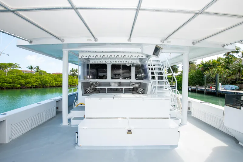 Sarah B Yacht Photos Pics Custom Carolina 58 Dixon Marine 2007 yacht deck with seating and stairs, docked by lush greenery.